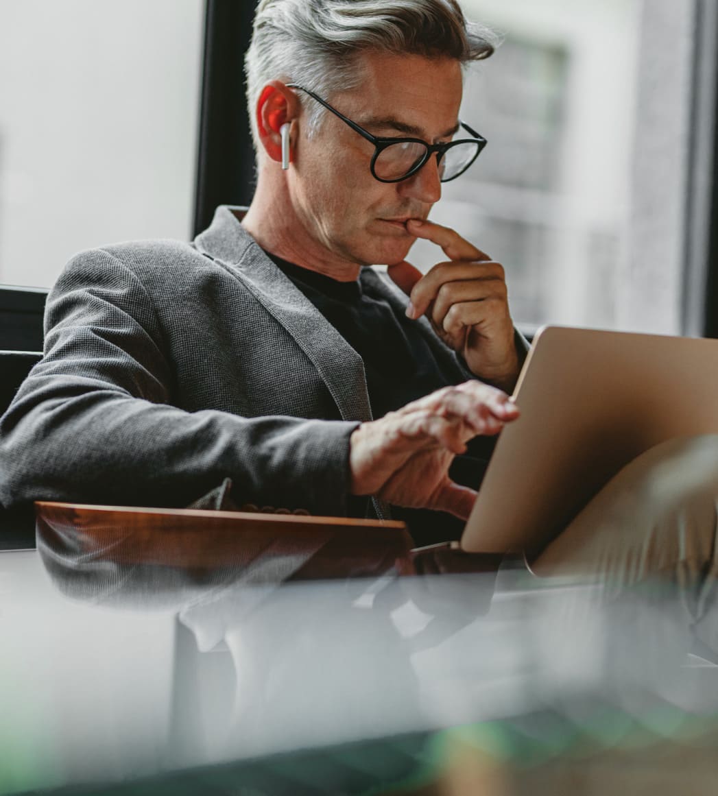 Geschäftsmann sitzt auf einem Sessel am Laptop