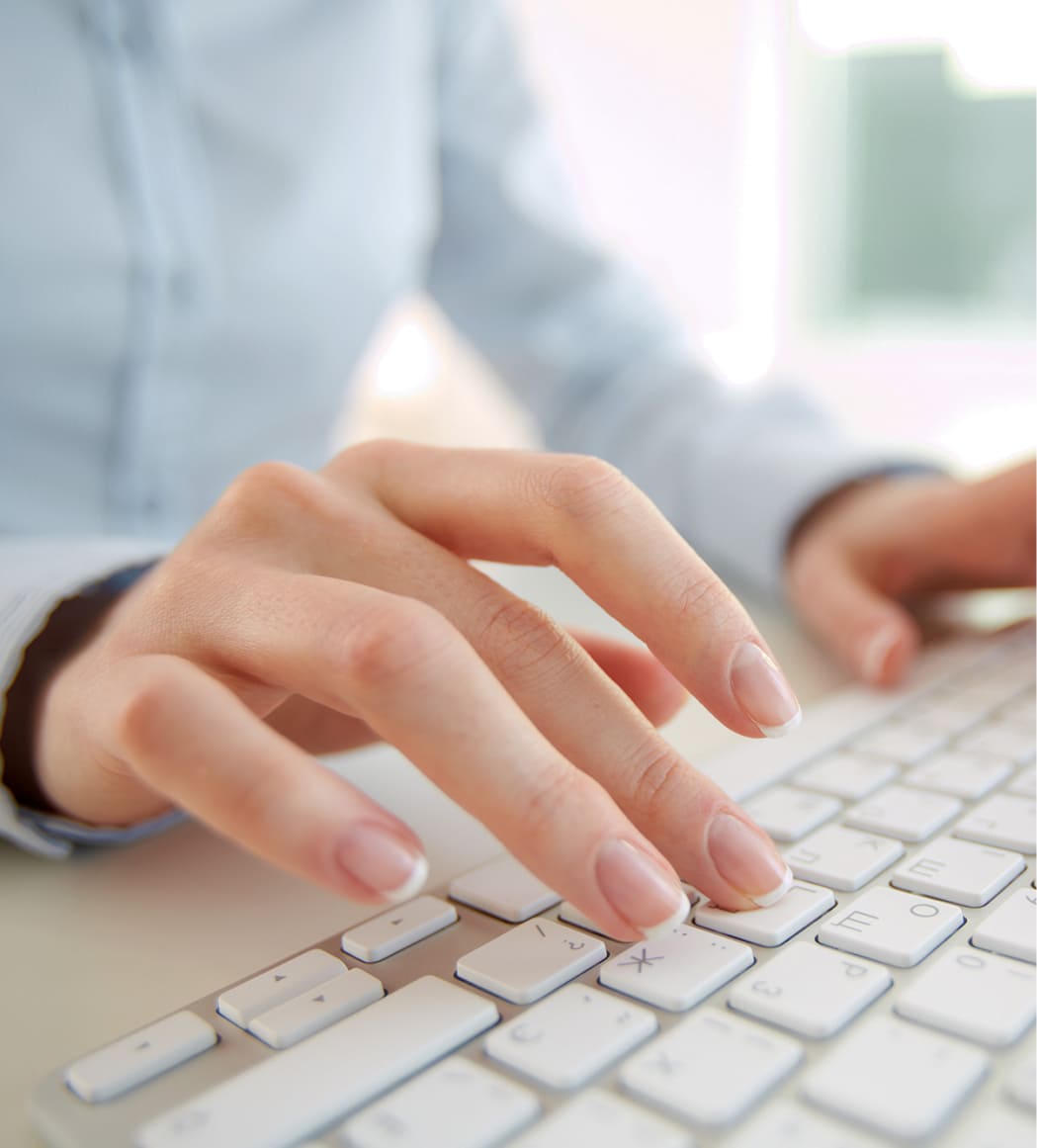 Hände einer Frau tippen auf eine Tastatur